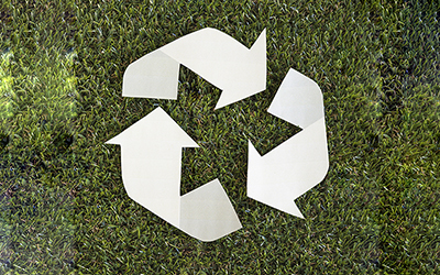 Paper recycling arrows on grass