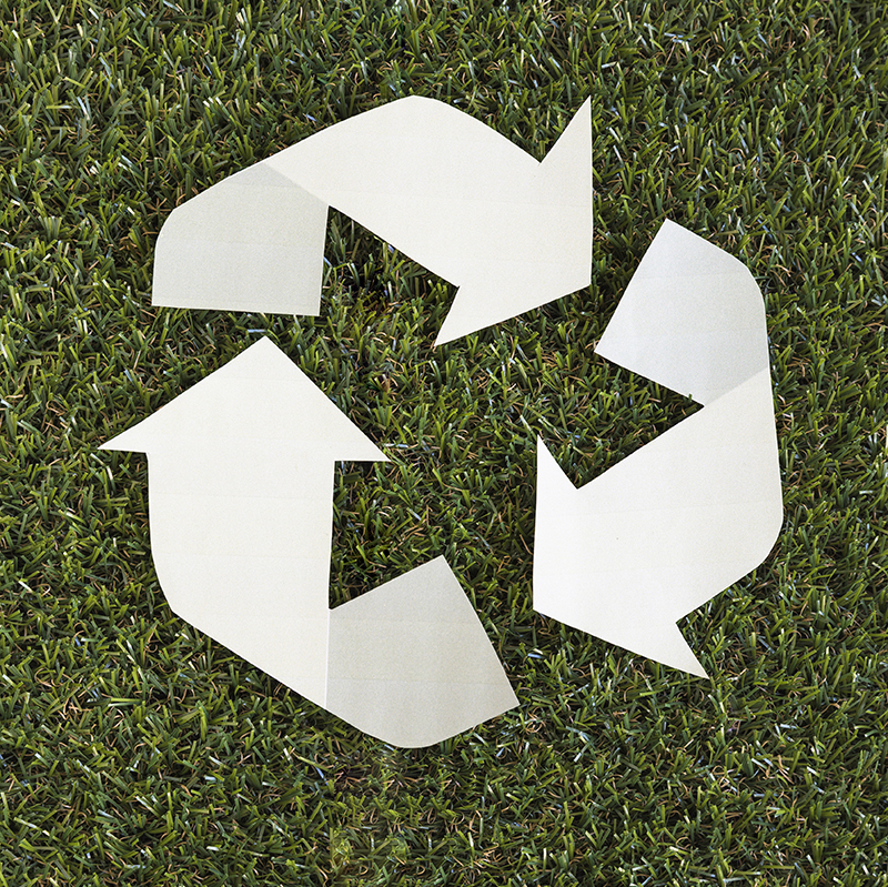 Paper recycling arrows on grass, square image